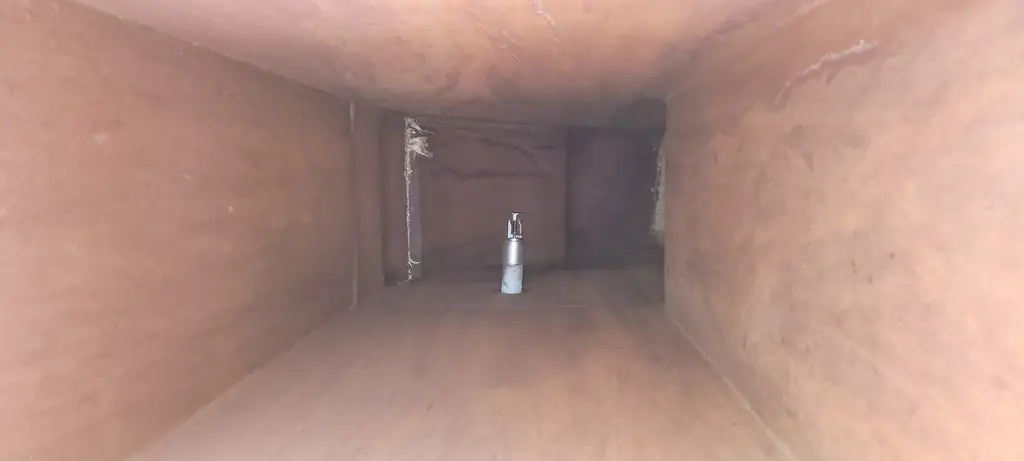 Looking down the inside of a cleaned rectangular sheet-metal duct toward the far opening